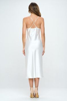 Turn heads with our stunning white satin slip dress. This elegant dress features delicate spaghetti straps, a crisscross back, and a chic side slit, creating a sophisticated and modern look. Perfect for formal occasions or evening events, this dress will make you stand out in any crowd. Satin Finish: Adds a luxurious and smooth feel to the dress. Spaghetti Straps: Thin, delicate straps for a comfortable fit. Crisscross Back: Unique design element for added style. Side Slit: Enhances the design w